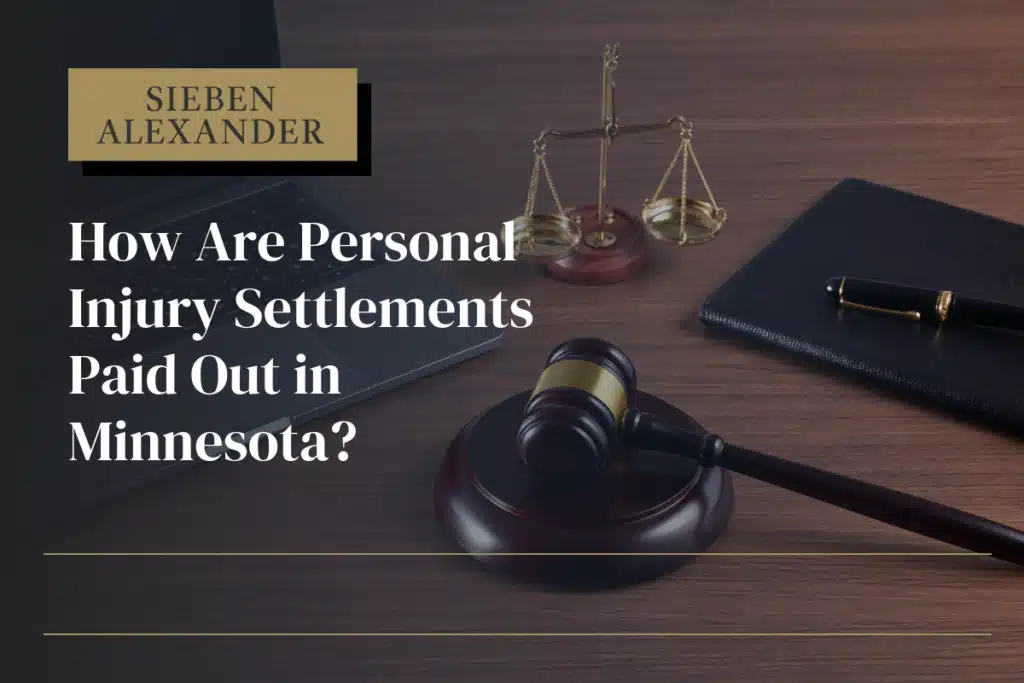 A judges desk featuring a laptop, scale, and gavel with the text "How are personal injury settlements paid out in Minnesota?"