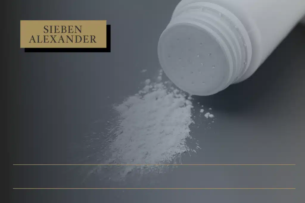 A white talcum powder bottle on its side with talcum powder on the table