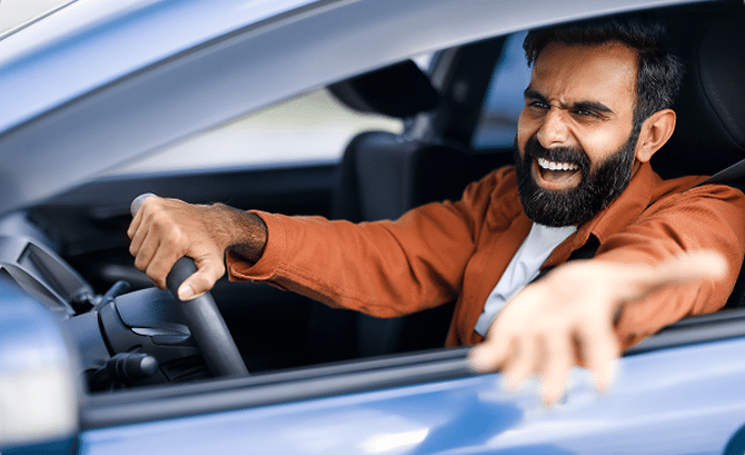 A man experiencing road rage and holding his hand out a car window