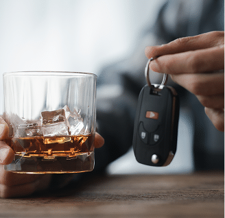 Close up of a car key next to an alcoholic beverage