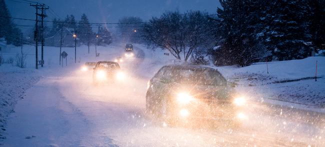 Cars driving in the snow at night