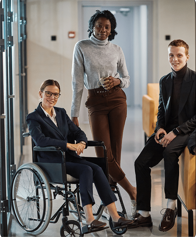 A diverse work team with 3 people looking at the camera