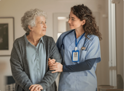 a nurse walking an elderly woman down a hall