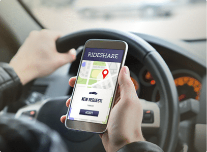 a person driving holding their phone that has text on it that reads "rideshare"