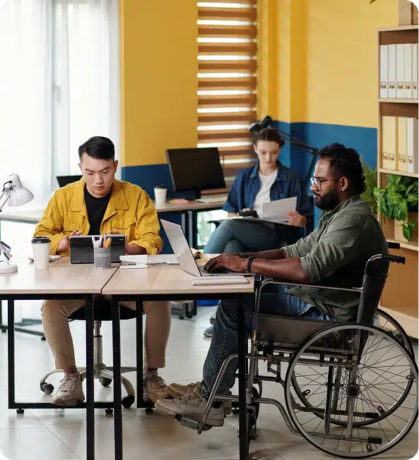 three people sitting, working at a desk