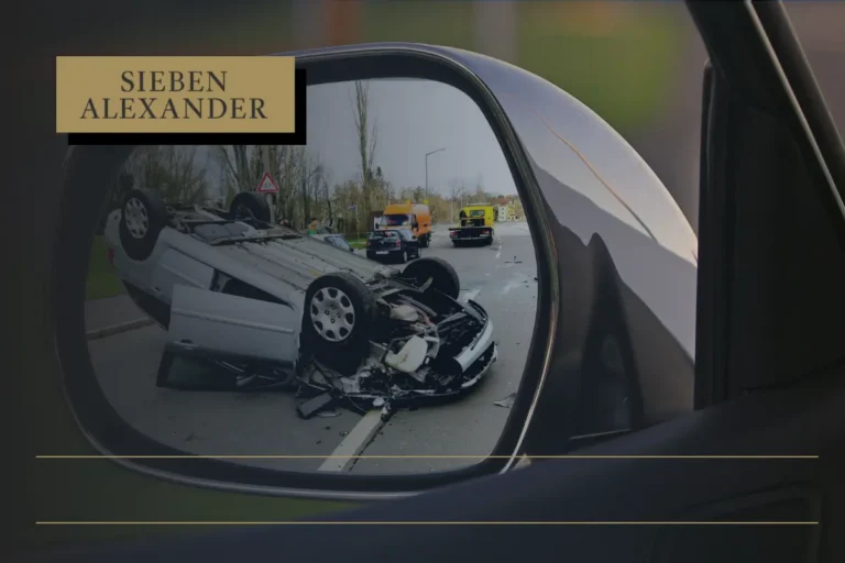Image in the driver side mirror showing a car accident.