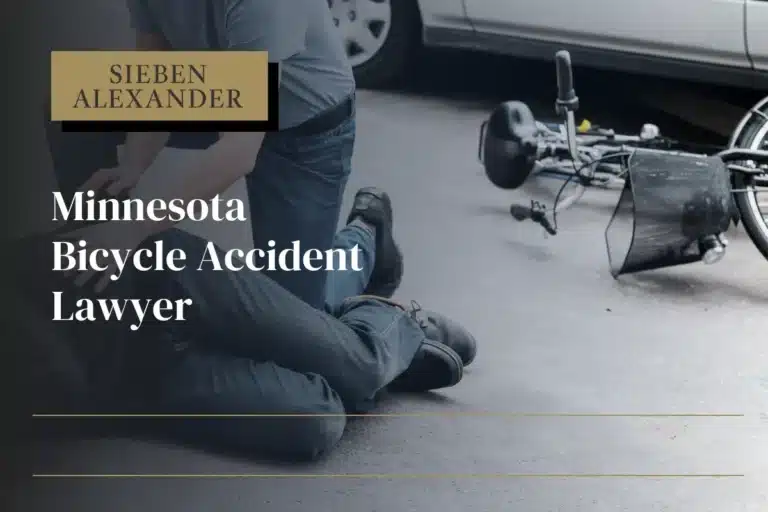 An adult who is laying on the ground next to a bicycle. Another adult is checking on them with the text "Minnesota Bicycle Accident Lawyer"