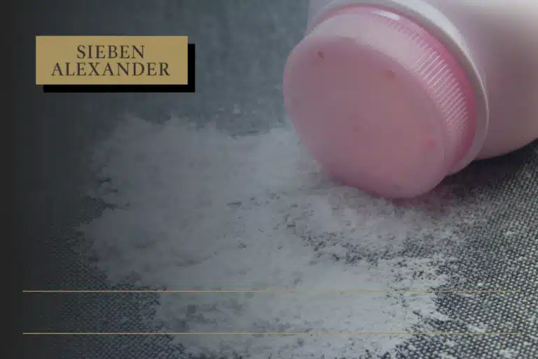 A pink talcum powder bottle on its side with contents spilled onto the surface
